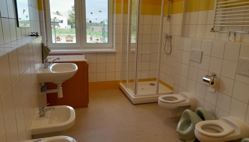 A tágas, többfunkciós szociális helyiségben a zuhanyzó mellett, pelenkázó asztal is található (A szerző felvétele)