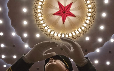 China Party, egy ember a Kínai Kommunista Párt rendezvényén, mennyezeten piros csillaggal és kör
