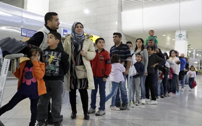 Greece Migrants, görög migránsok sorakoznak egy épületben, felnőttek és gyerekek. Mindannyian