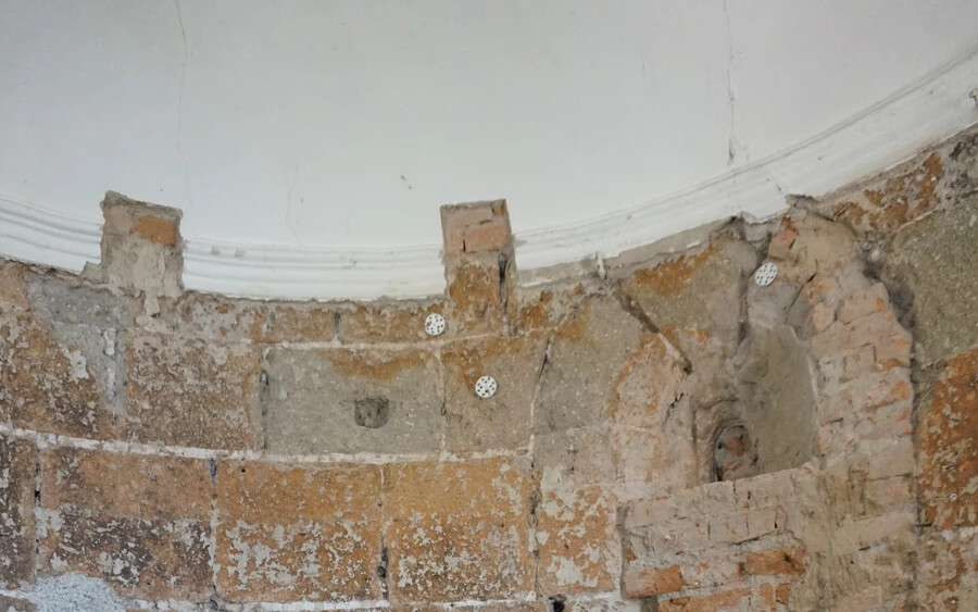 Juraj Puškár háttérben a román kori ablakkal, alatta pedig az eddig ismeretelen földrengés nyomait magán viselő repedéssel (Vataščin Péter felvétele)