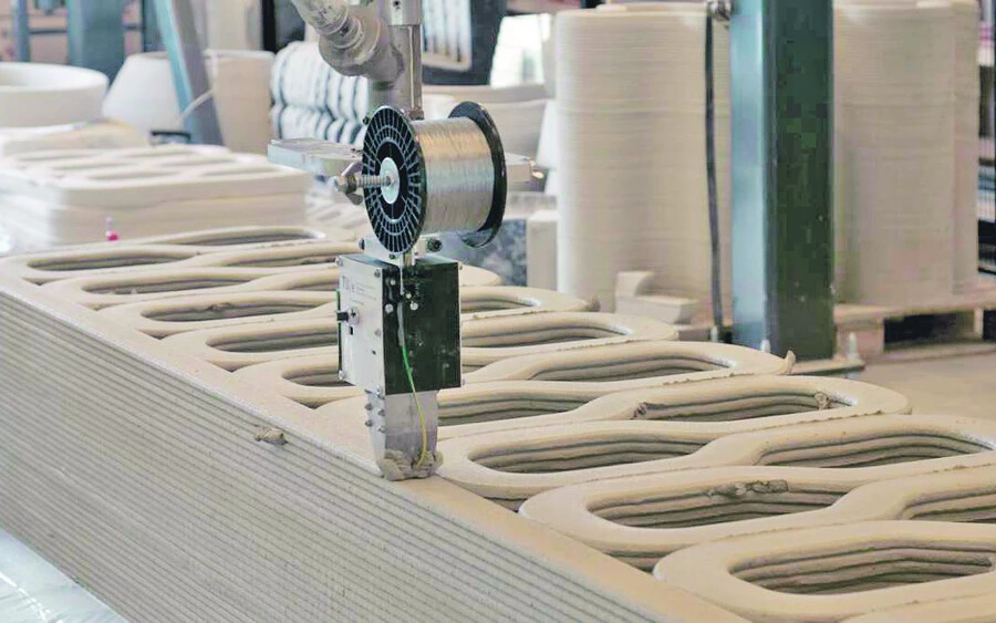 Az építéshez használt 3D-s nyomtató lényegében egy hatalmas robotkar a végén fecskendővel, amely kilövelli a különleges cementet