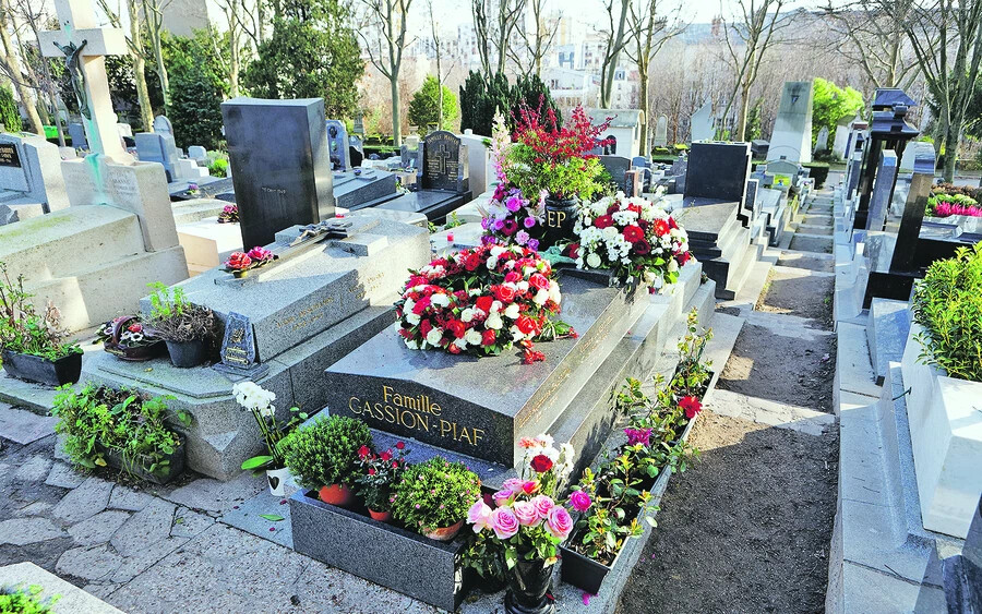 Ebbe a sírba temették Edith Piafot. Sírkövére ezt vésték: „Madame Lamboukas, dite Édith Piaf” (Lamboukasné, akit Édith Piafnak hívtak). Sírhelye a temető 97. parcellájában található. Édith Piafon kívül itt nyugszik édesapja, Louis-Alphonse Gassion († 1944) és kislánya, Marcelle, aki 2 éves korában, 1935-ben halt meg, valamint Piaf özvegye, Théo Sarapo (Théophanis Lamboukas) is, aki 1970-ben autóbalesetben veszítette életét. (Fotó: Wikipedia/Pierre-Yves Beaudouin)