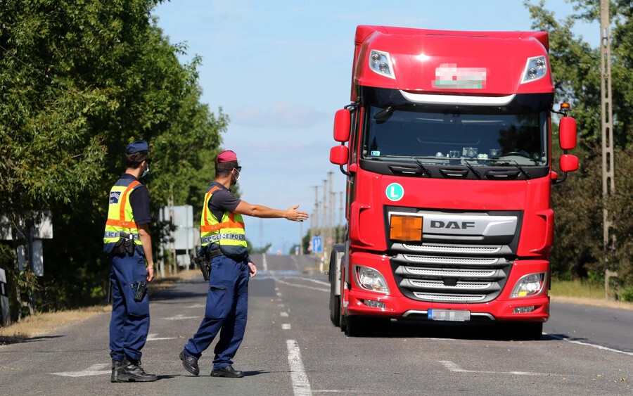 Rendőrök egy kamiont készülnek ellenőrizni a magyar-szlovák határon, a bánrévei határátkelőn 2020. szeptember 8-án