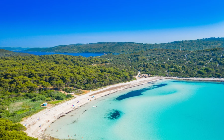 A Sakarun strand a Zadar régióban található Dugi Otok szigetén található, és türkizkék vizével és fehér homokos strandjaival egy rejtett gyöngyszem. A strandot fenyőerdők veszik körül, békés hangulatáról és látványos naplementéiről ismert. Ez a strand számos tevékenységet kínál a látogatóknak.