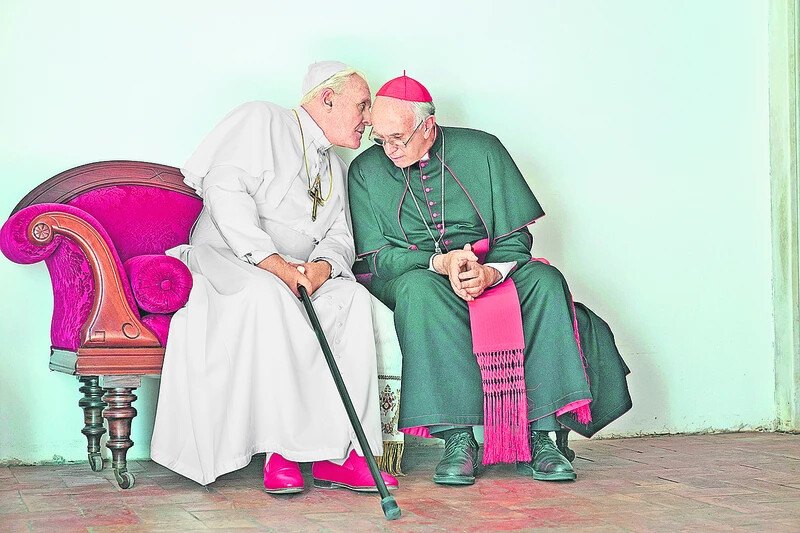 onathan Pryce mint Bergoglio érsek (jobbra) és  Anthony Hopkins mint XVI. Benedek pápa A két pápa című filmben, amely jelölést kapott a legjobb drámai film díjára