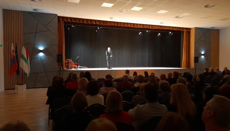 Iván Lajos a mikrofonnál. A színpad két szélét különleges panelek díszítik (A szerző felvétele)