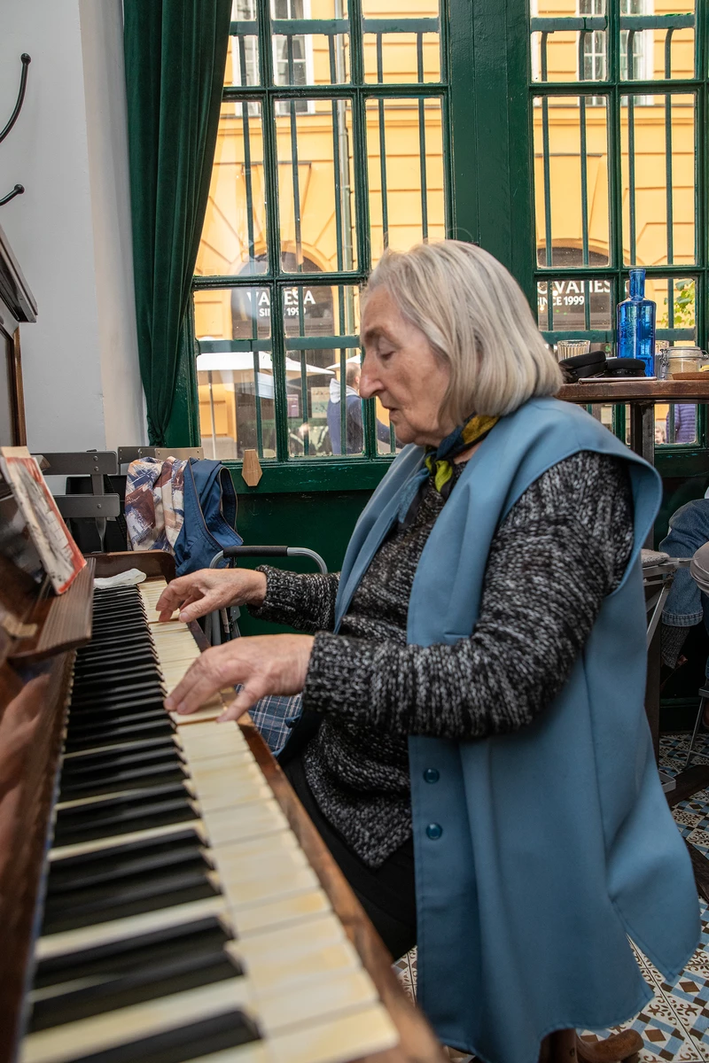 Marta asszony szép egyenesen ül a zongoránál, és bár fáradhatatlanul jár a keze a billentyűkön, bevallja, hogy fájdalmai vannak. 